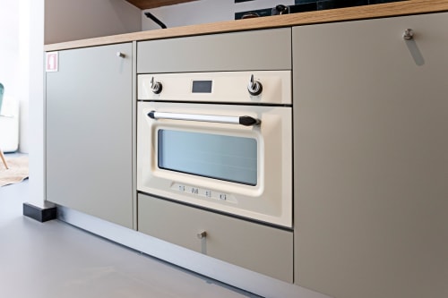 Forno embutido cor creme com micro-ondas e fogão na kitchenette Superior Studio do hotel Benefit Collection, Porto