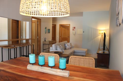Modern living room at Seahorse House by Break Lovers in Tavira with wooden table, turquoise candles, wicker chairs, and