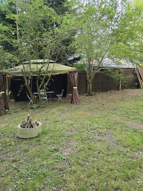 Installation de camping privée au Domaine Trianon à Villandry : tente toile, coin détente, foyer et jardin luxuriant