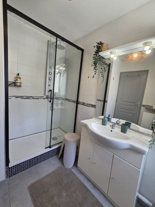 Salle de bain moderne à la Résidence Cosy avec douche italienne, vasque blanche et plantes décoratives à Saint-Méen-le-Grand