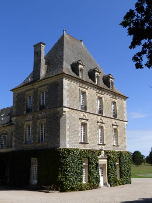 Tour en pierre du château avec toit mansardé au Château d'Alexis de Tocqueville, Tocqueville, France, base couverte de lierre