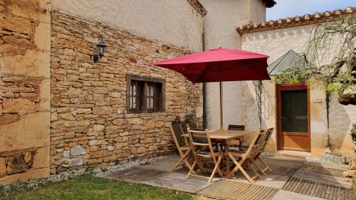 Privéterras van Gîte Cristal met tafel en tuinmeubilair.