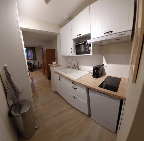 Modern kitchen in Sunflowers and Poppies cottage at Les Gites de Campardon with white cabinets, wooden countertops, and