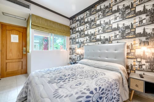Habitación doble en Hostal El Molino de Collado Villalba con papel tapiz temática urbana, cabecero tapizado blanco y madera