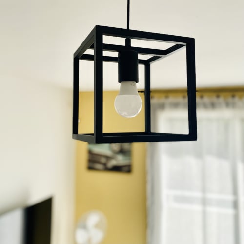 Luminaire suspendu cubique noir moderne avec ampoule dépoli dans l'appartement Ibis Rouge aux Maisons En Or, Sinnamary