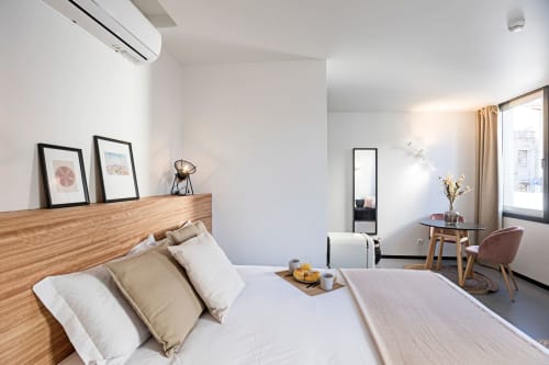 Moderno apartamento estúdio no Porto com cama de madeira, roupas de cama brancas, decoração minimalista, mesa de trabalho e vista para a cidade