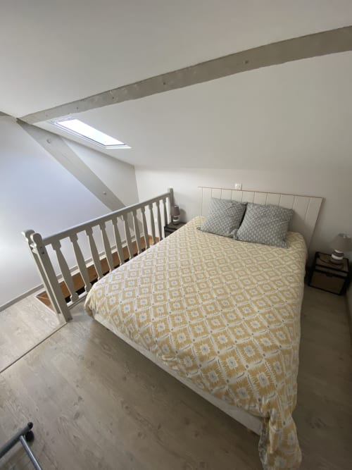 Chambre mansardée lumineuse au Cocon De Curson avec lit queen-size, lit bébé, puits de lumière et vue jardin à Chanos-Curson