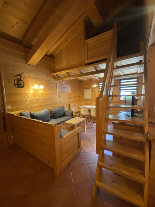 Intérieur cosy en bois avec canapé, mezzanine et escalier à La Ferme des Georgières à Notre-Dame-de-Bellecombe