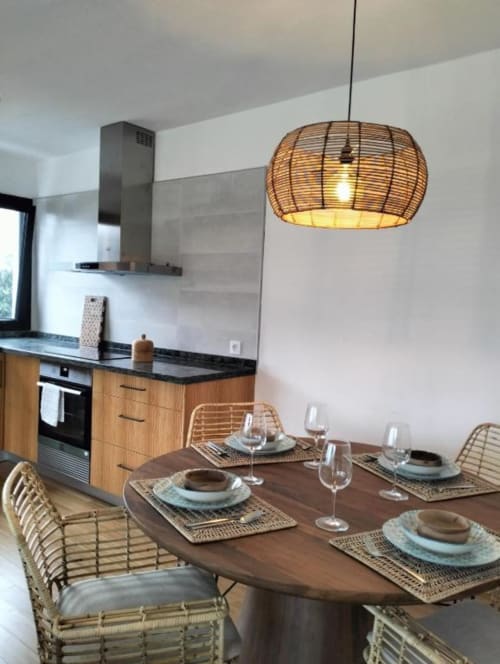 Comedor moderno en villa Nexus de Rural La Palma con mesa de madera, sillas tejidas, lámpara colgante de ratán y equipada