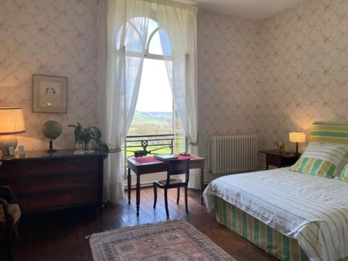 Chambre élégante au Château de Vaux Morvan avec vue sur le jardin, mobilier ancien et décor français classique