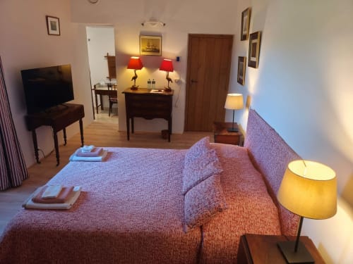 Chambre cosy à la Magnanerie de Sainte Croix avec lits jumeaux, mobilier en bois, lampes rouges