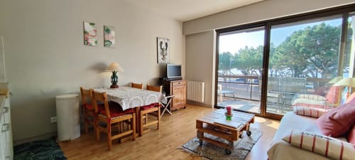 Appartement lumineux à Mer et Maisons avec table à manger en bois, balcon vue mer, TV et mobilier moderne à La Trinité sur