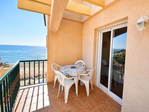 Beachfront apartment terrace with sea view, white dining furniture, and coastal setting in Cuevas del Almanzora