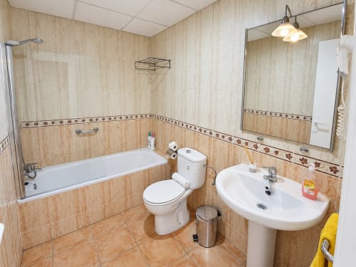 Modern bathroom with bathtub, toilet, and sink at Apartamentos El Calón Playa, Cuevas del Almanzora