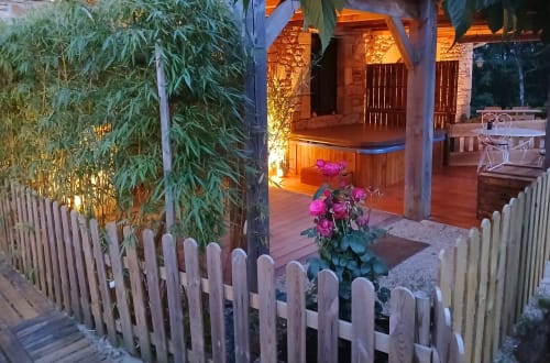 Sfeervol verlicht privéterras met jacuzzi van Suite Ambre bij Domaine du Cardou