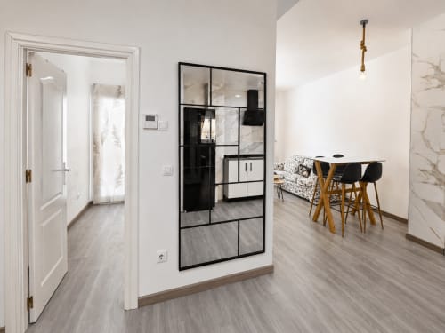 Elegante interior de apartamento moderno en El Calón Playa con sala abierta, comedor, divisiones de cristal y detalles en mármol