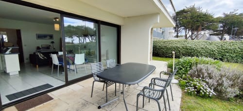 Terrasse contemporaine à Mer et Maisons avec table à manger, chaises et vue sur la mer à La Trinité sur Mer