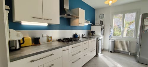 Cuisine moderne à la villa Mer et Maisons, La Trinité sur Mer, avec armoires blanches, mur d'accent bleu, cuisinière à gaz
