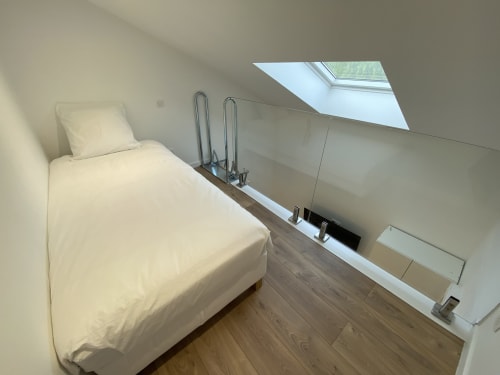 Bright attic bedroom at La Maison Blanche with single bed, skylights, wooden floors, and modern amenities in Bouguenais