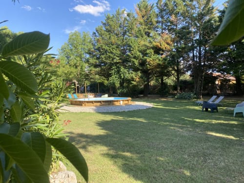 Jardin spacieux du gîte Le Cocon De Curson à Chanos-Curson avec piscine bois, transats et grands arbres