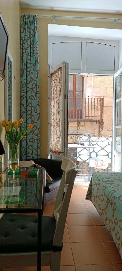 Habitación moderna en la Pensión Alicante San Nicolás con cortinas de patrón turquesa, balcón con vista a la ciudad, estilo contemporáneo