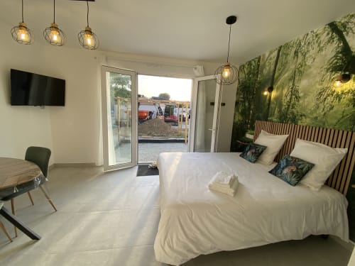 Studio moderne La Maison Blanche avec vue jardin, lit blanc, luminaires suspendus, TV et portes-fenêtres à Bouguenais