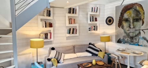 Suite moderne aux Chambres du Keriolet à La Trinité-sur-Mer avec canapé gris, lampes jaunes et étagères intégrées