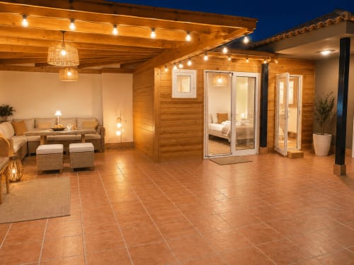 Terrasse en bois luxueuse à Sara & Gino Fuerteventura avec salon, guirlandes lumineuses et vue sur la mer