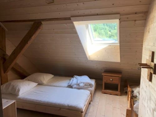 Cozy attic bedroom with skylight, wooden beams, and mountain views at Les Chalets de l'Eau Rousse cottage in French Alps