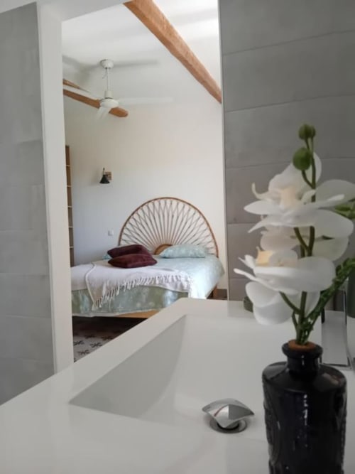 Vasque de salle de bain moderne avec fleurs blanches à Chez Laure & Marc, suite avec vue sur le jardin à Plaissan, France