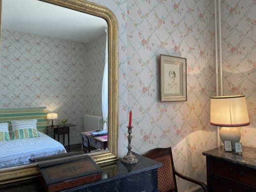 Chambre élégante au Château de Vaux Morvan avec papier peint fleuri, miroir doré et vue sur le jardin à Étang sur Arroux