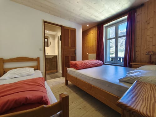 Camera 4 Chalet Coste Belle: camera alpina con due letti in legno, vista sulle montagne, pareti in legno e servizi moderni a Ceillac