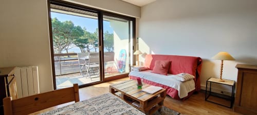 Lumineux appartement côtier à Mer et Maisons avec canapé rouge, balcon vue mer et mobilier en bois à La Trinité sur Mer