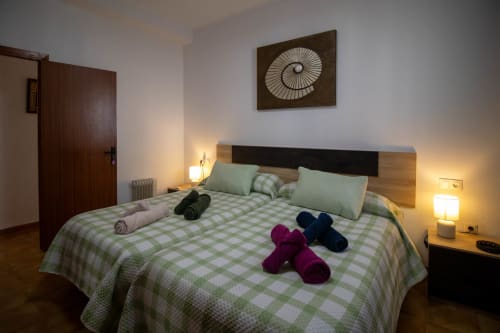 Acogedora habitación en La Casa de Tita Clota en Setenil de las Bodegas con ropa de cama a cuadros verdes y amenidades de bienvenida