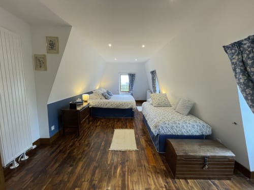 Chambre twin lumineuse au cottage Château de Vaux Morvan avec vue sur jardin, parquet et plafonds mansardés
