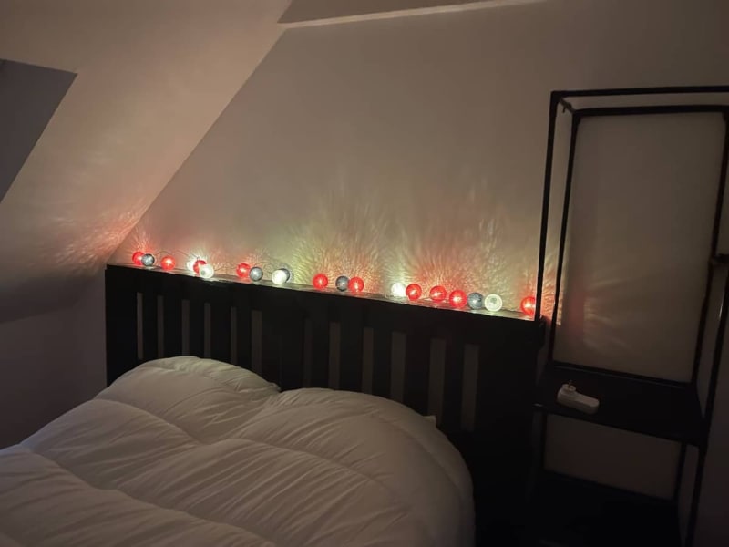 Tête de lit noire avec LED rouges et blanches au-dessus de la literie blanche à la villa Le Bovary des Gites De Flaubert