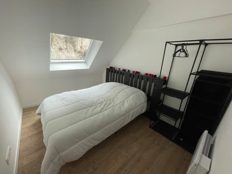 Chambre mansardée moderne aux Gites De Flaubert avec literie blanche, lit à structure métallique noire, fenêtre de toit, parquet