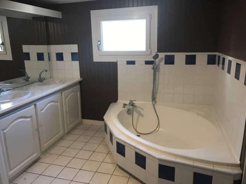 Salle de bain moderne de la villa Les Gites De Flaubert avec baignoire d'angle, double vasque et accents de carrelage foncé