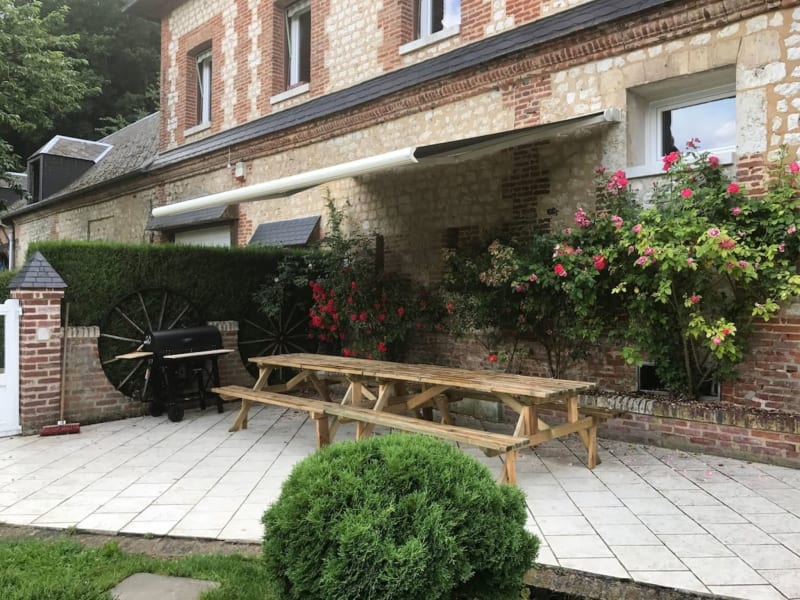 Charmant patio en brique aux Gites De Flaubert avec table de pique-nique, roses grimpantes et store rétractable au Héron
