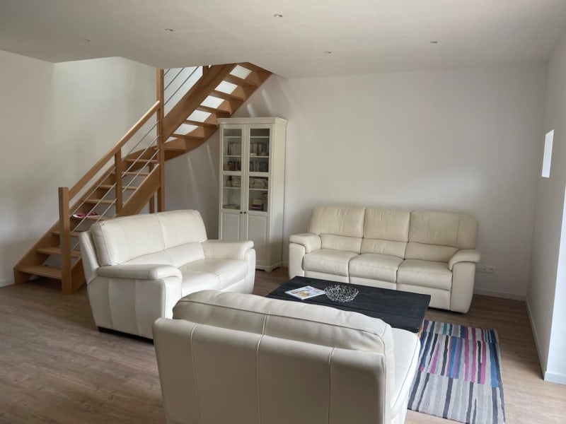 Salon ouvert moderne aux Gites De Flaubert avec canapés crème, escalier en bois et parquets