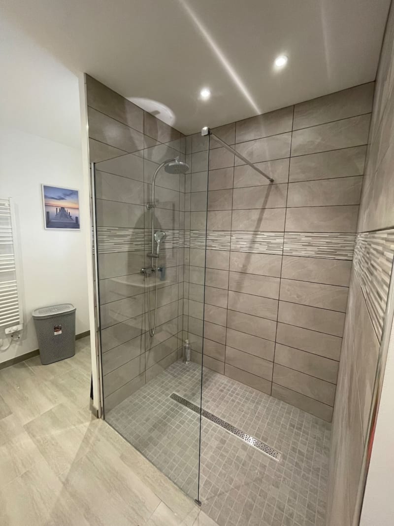 Douche moderne avec parois vitrées et carrelage horizontal aux Gites De Flaubert, Le Heron