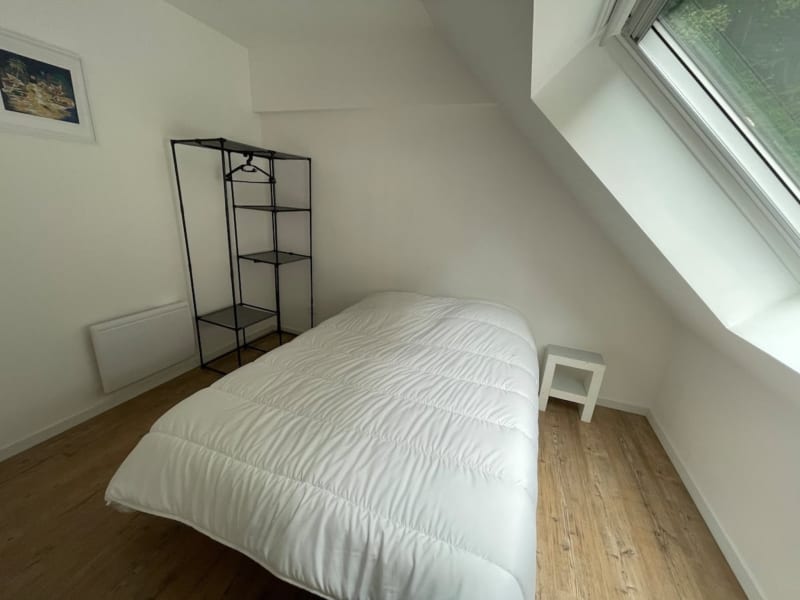 Chambre minimaliste sous les combles aux Gîtes De Flaubert avec literie blanche, puits de lumière et étagères métalliques