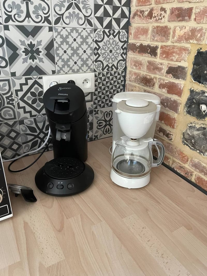 Comptoir de cuisine avec cafetière Philips noire et cafetière à filtre blanche à l'hôtel Les Gîtes De Flaubert.