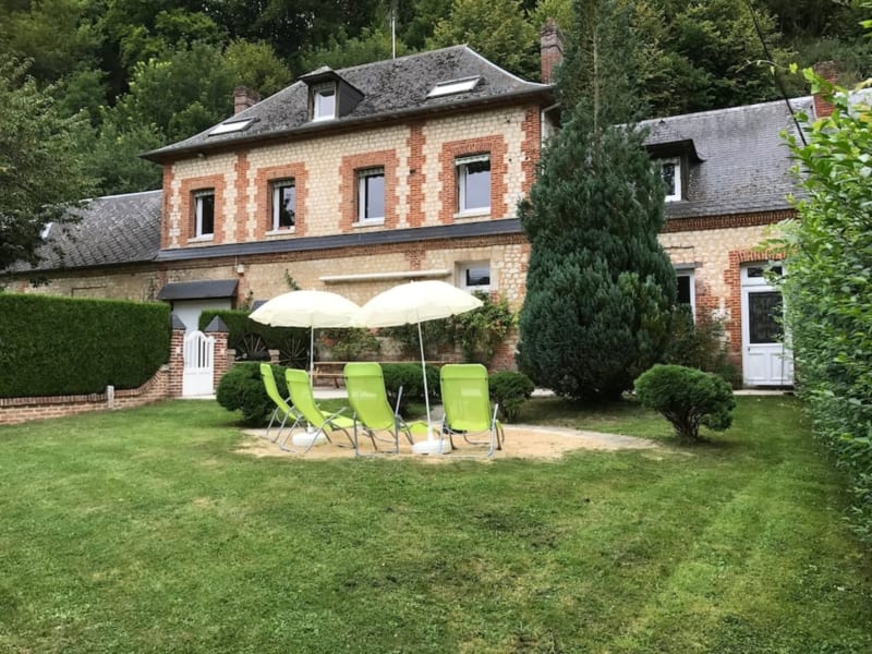 Maison de campagne en brique aux Gites De Flaubert avec chaises longues vertes sous parasol dans un jardin soigné