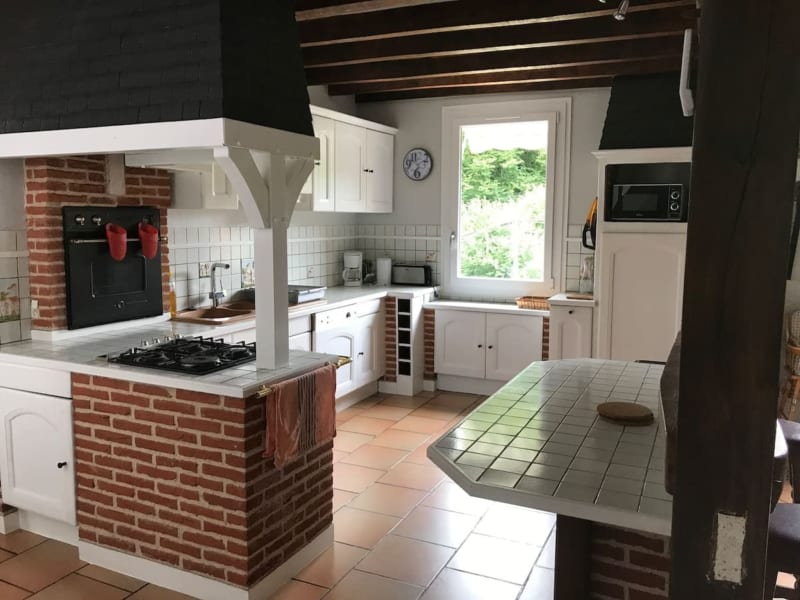 Cuisine lumineuse des Gîtes De Flaubert avec îlot en brique, armoires blanches et vue sur le jardin