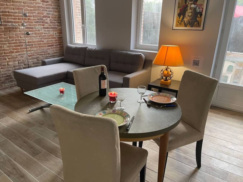 Salle à manger moderne avec table ronde et chaises crème à la villa Le gîte d'Emma aux Gites De Flaubert, avec poutres
