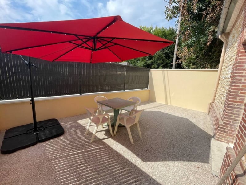 Parasol rouge ombrageant une petite table avec des chaises sur la terrasse de la villa Le gîte d'Emma aux Gites De Flaubert