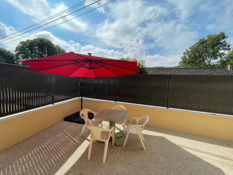 Parasol rouge ombrageant une table de terrasse aux Gîtes de Flaubert au Héron, France
