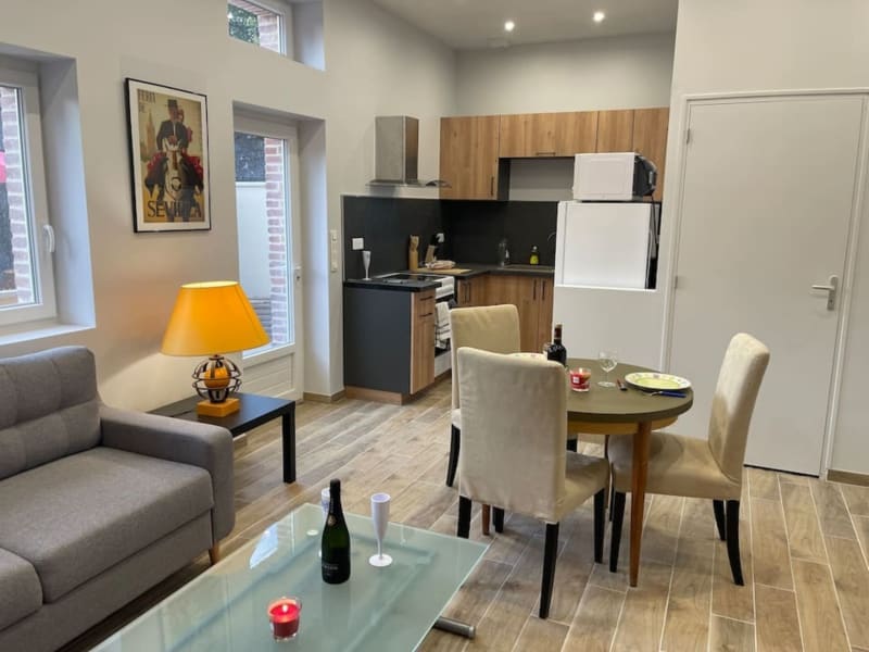 Studio moderne aux Gites De Flaubert : séjour, kitchenette, table et canapé gris à Le Héron