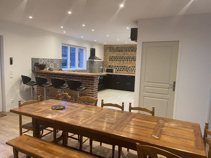 Salle à manger contemporaine à la villa Le Bovary aux Gîtes De Flaubert avec table en bois, cuisine aux détails de brique et coin bar